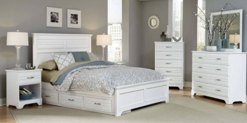 A bedroom with a white bed and furniture.