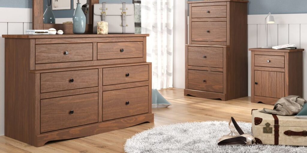 A bedroom with a dresser, chest of drawers, and a mirror. This collection offers versatile and durable furniture solutions.