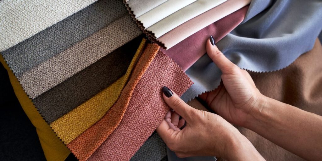 A person holding a fabric sample in their hand.