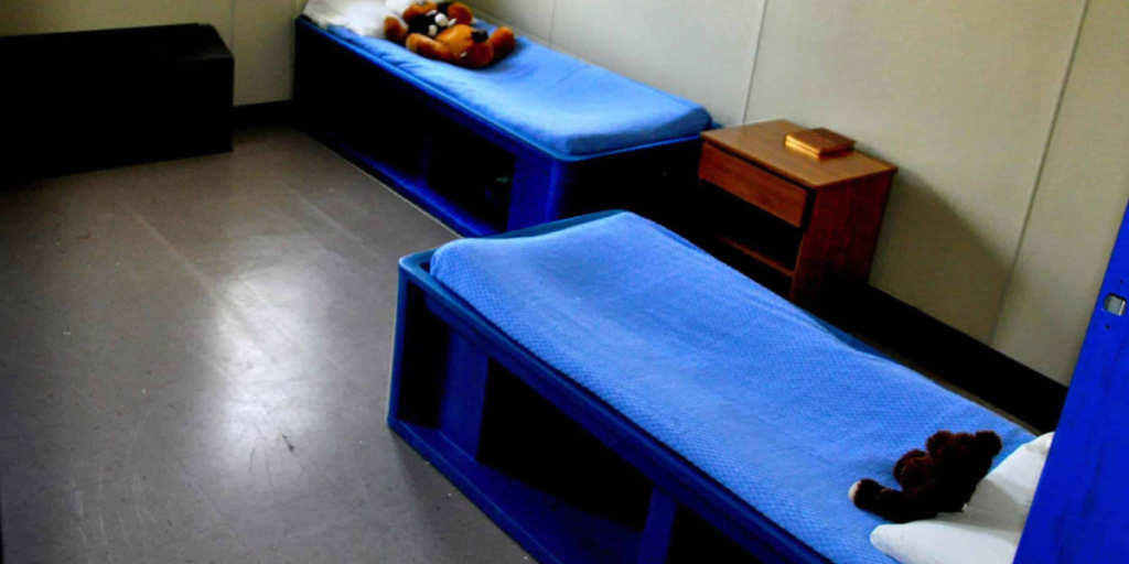 A hospital room featuring two adjustable beds and a teddy bear, designed for patient comfort and care.