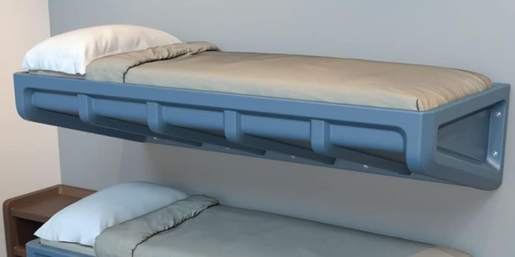 Two beds in a room with a wall-mounted shelf, designed for comfort and functionality for patients with limited mobility.