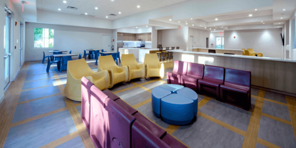 A spacious lobby featuring vibrant chairs and tables, creating an inviting atmosphere for visitors and patients.