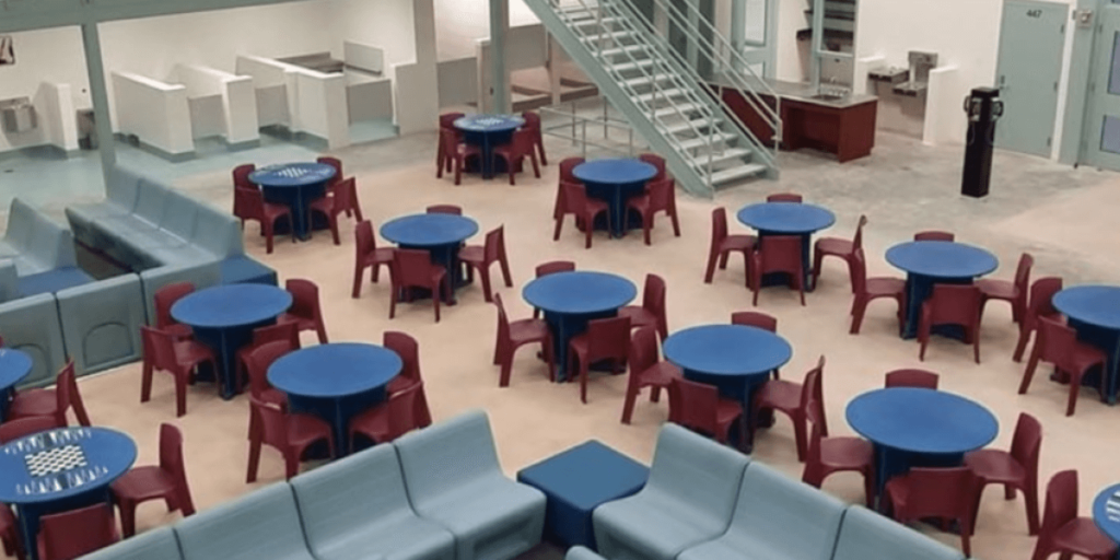 A room furnished with tables and chairs, suitable for meetings or gatherings in a professional setting.