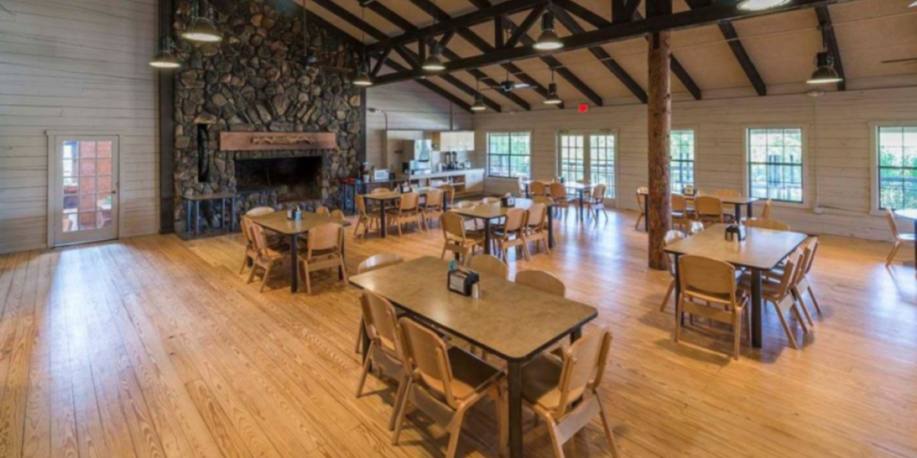 A cozy dining room at the lodge, featuring wooden furniture, inviting ambiance, and views of the nearby falls.