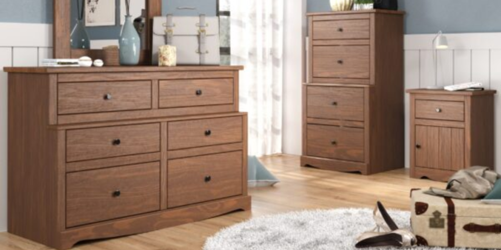 A well-furnished bedroom featuring a dresser, chest of drawers, and a mirror, ideal for transitional housing needs.