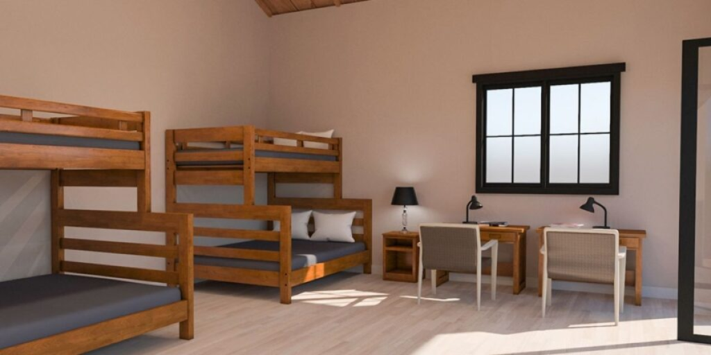 Bunk beds in a room designed for crisis housing, featuring a sturdy desk and a calming aesthetic for residents' comfort.
