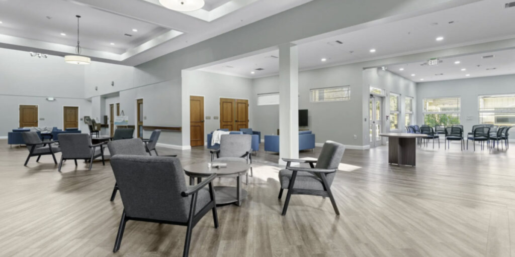 Dining room in a senior living community featuring inclusive furniture for social interaction and comfortable dining for all residents.