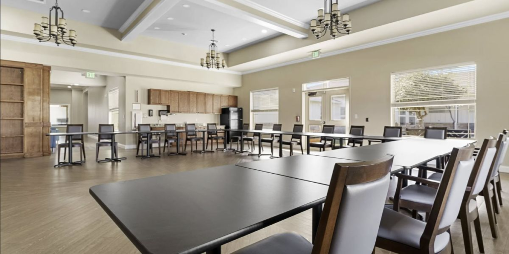 A spacious room furnished with tables and chairs, designed for accessibility and inclusivity for all individuals.
