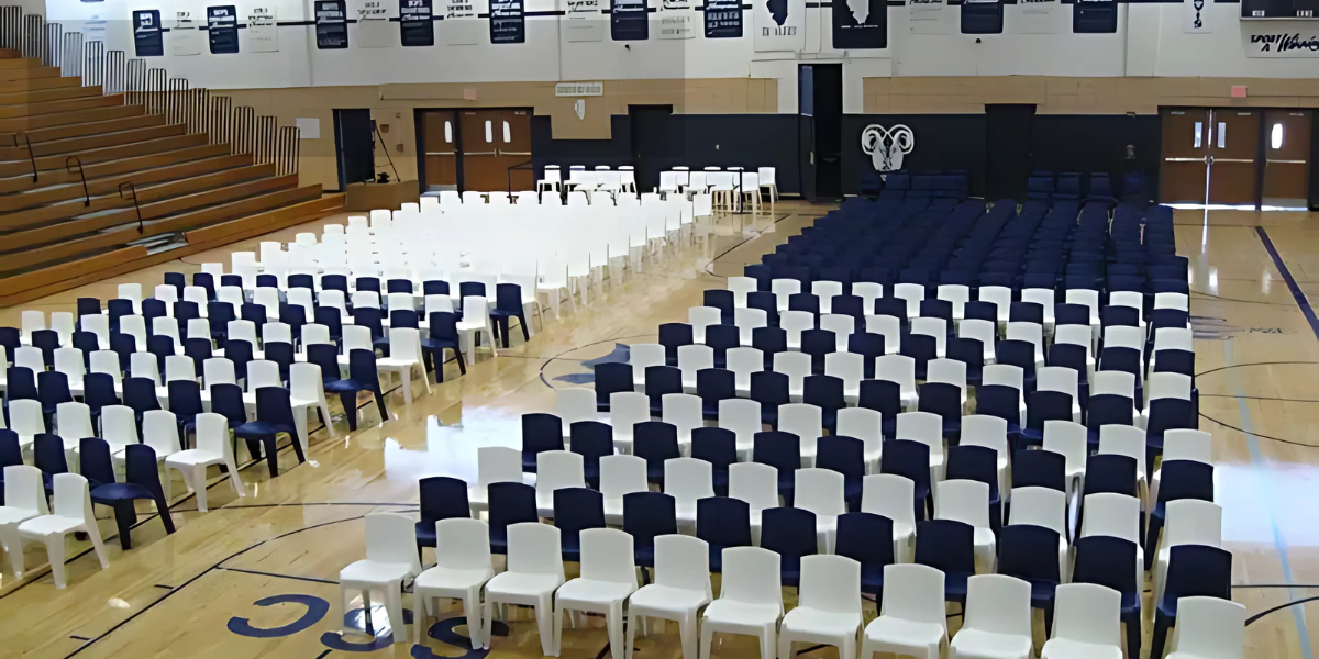 A spacious gym featuring rows of chairs and bleachers, designed for events and gatherings.