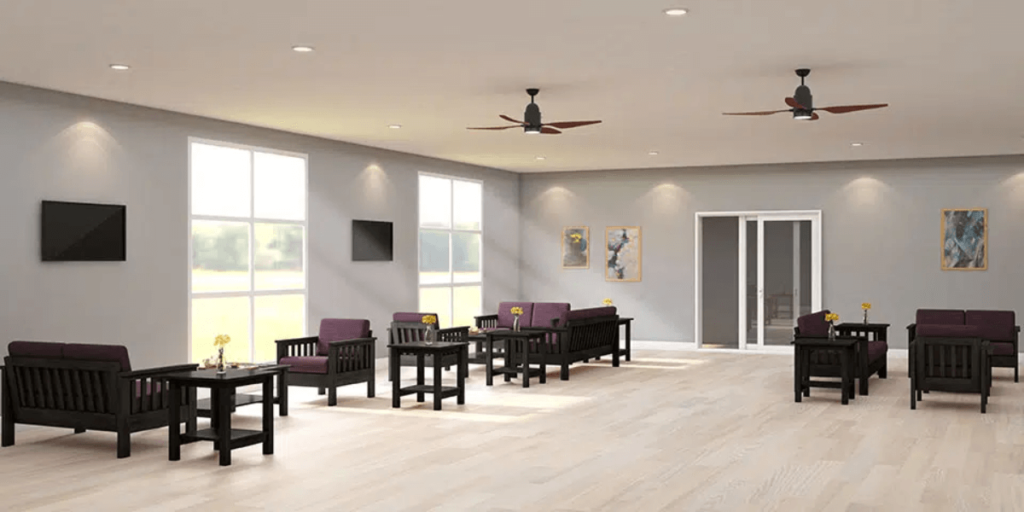 A spacious room featuring a ceiling fan and several chairs, designed for comfort in high-use environments.