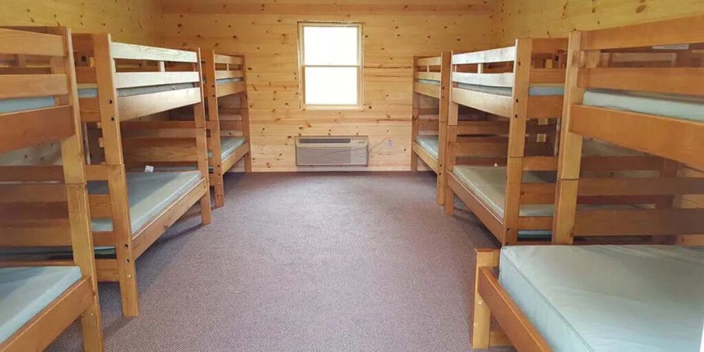 Bunk beds in a cabin with a window, showcasing durable design for behavioral healthcare and transitional housing settings.