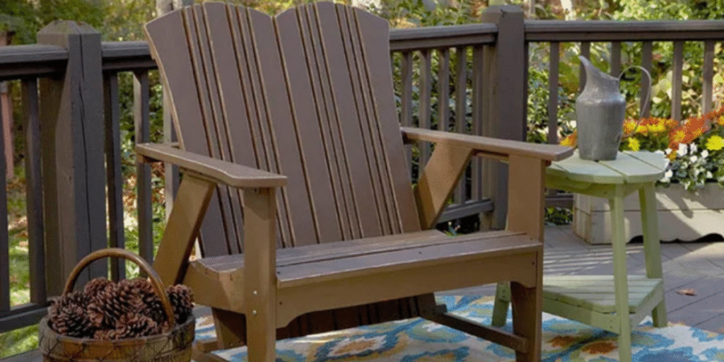 A wooden chair on a deck beside a table adorned with flowers, illustrating a versatile outdoor space for various activities.